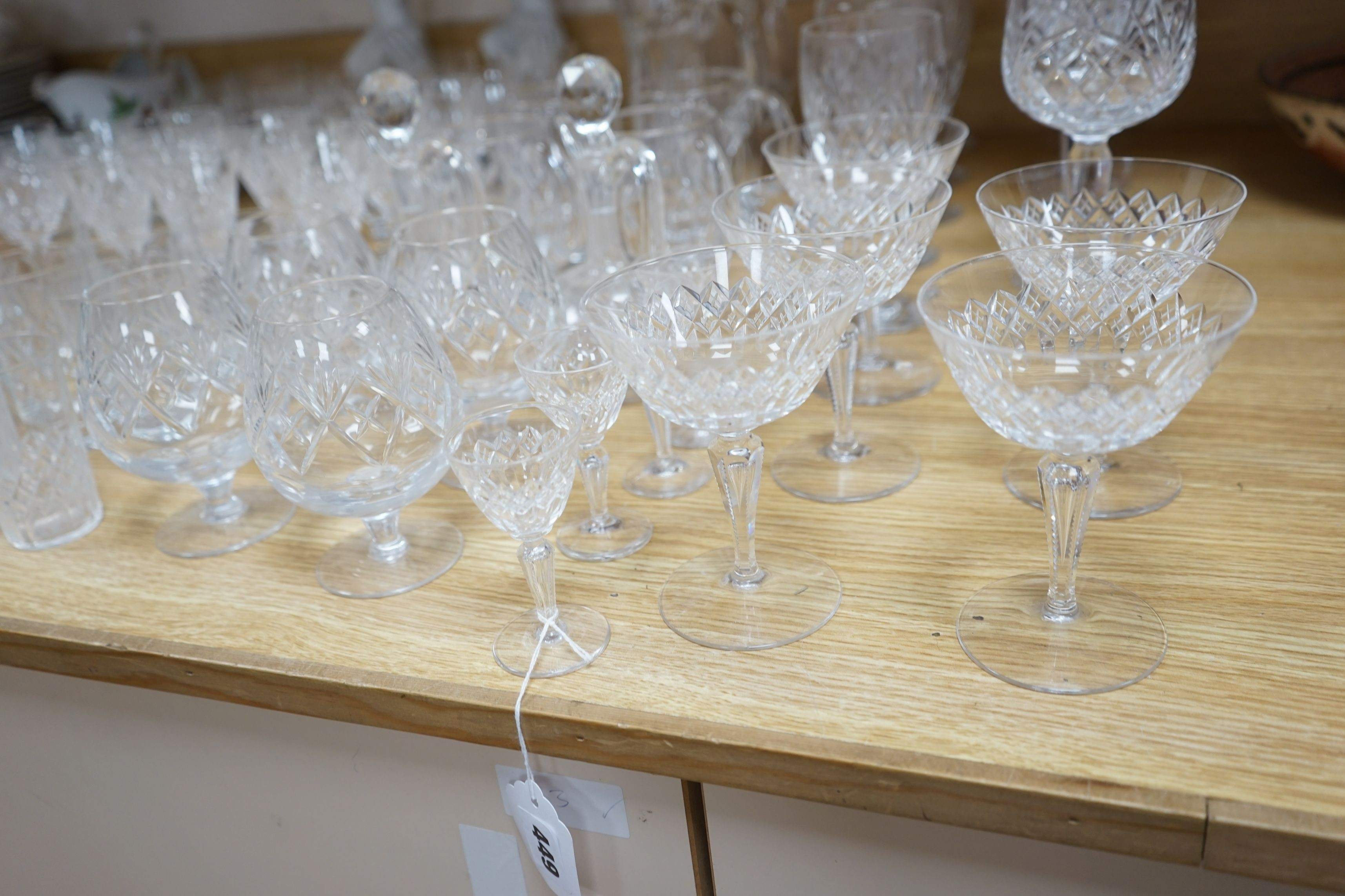 A suite of cut drinking glassware and a pair of porcelain figural lamp stems
